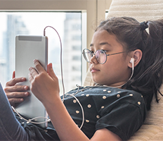 Girl wearing headphones and using a tablet